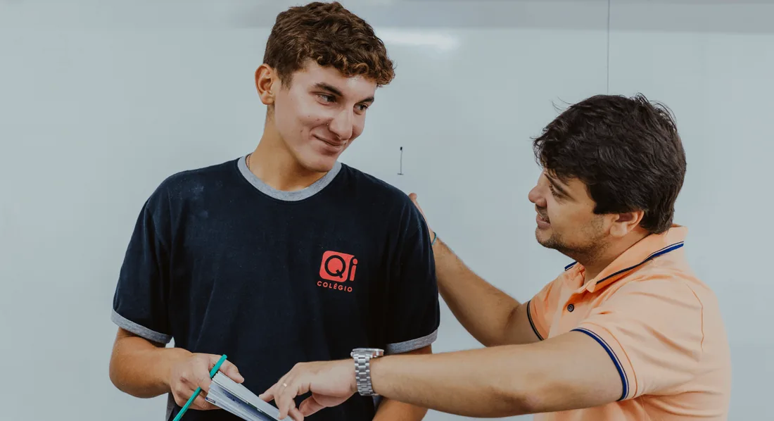 Aluno do Ensino Médio recebendo orientação de um professor